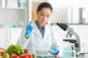 Young female nutritionist testing food samples in laboratory